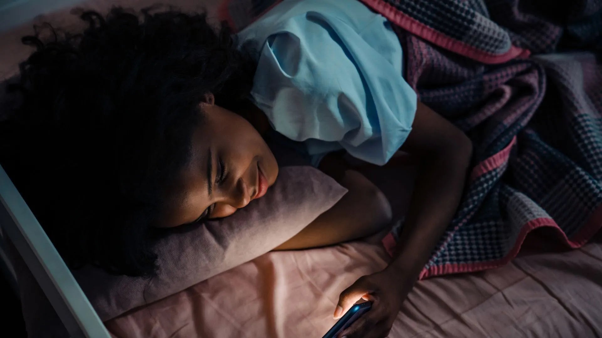 A teenager peacefully sleeping, illustrating the importance of adequate sleep for their health and development.