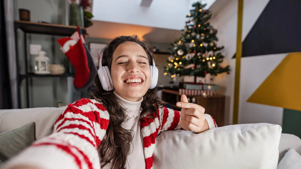 A group of friends enjoying a virtual Secret Santa gift exchange over a video call, with festive decorations in the backgrou