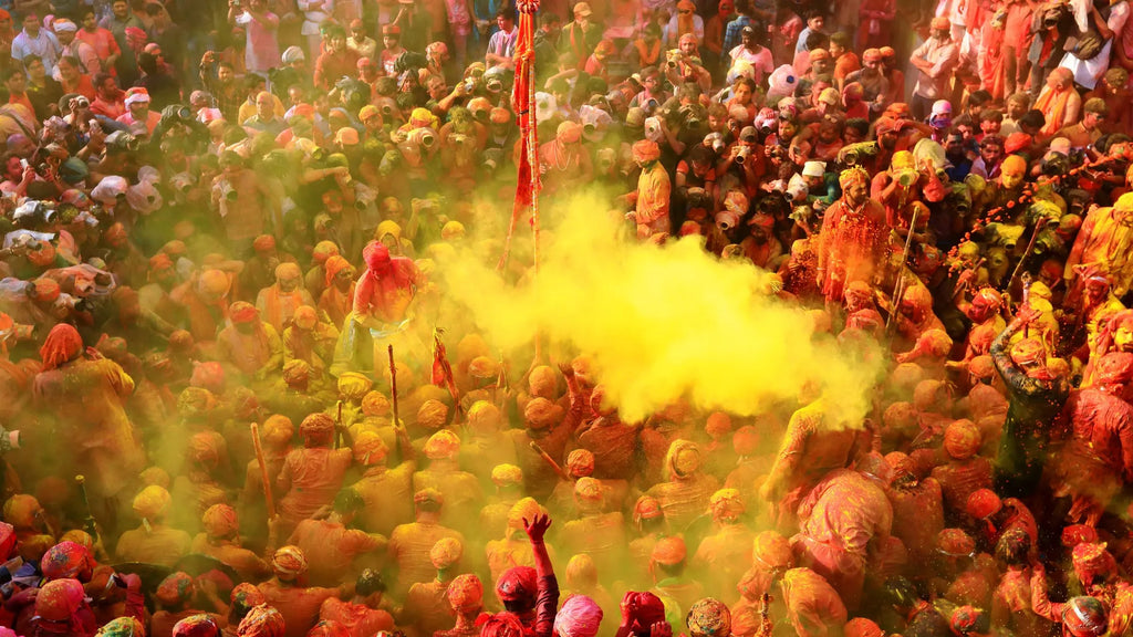 Vibrant scene of Barsana Lathmar Holi with colorful powders and joyful participants celebrating together.